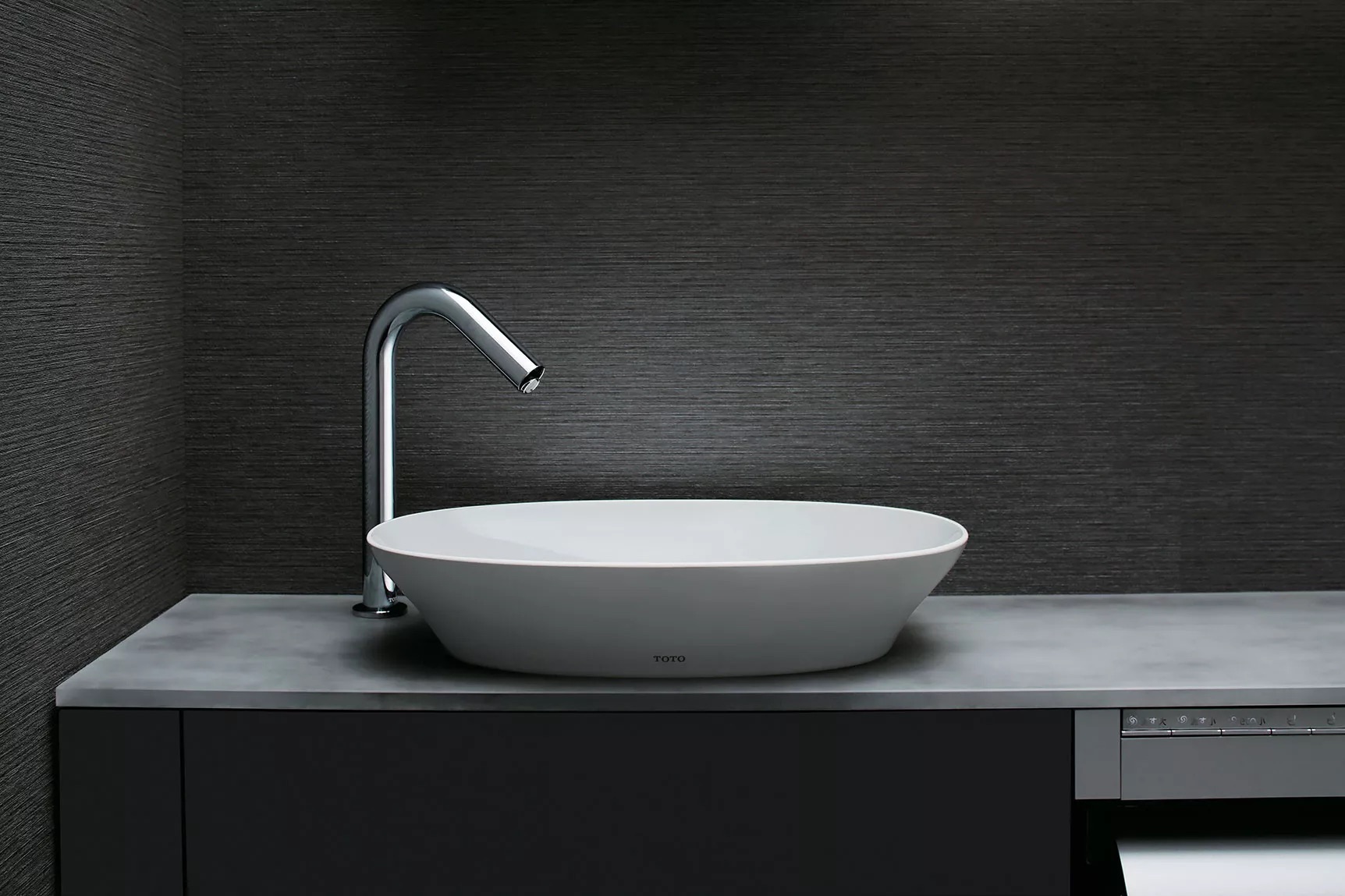 A TOTO KIWAMI oval vessel lavatory on a slate countertop. Image courtesy of TOTO USA.