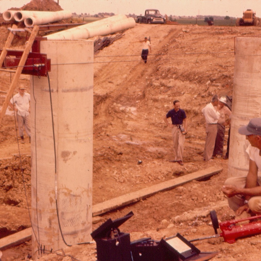 Jack Janney, in the dark shirt, watches construction of the Beverly Road Bridge on the Illinois Tollway around 1957, built with precast, prestressed concrete girders. Photo courtesy of WJE.