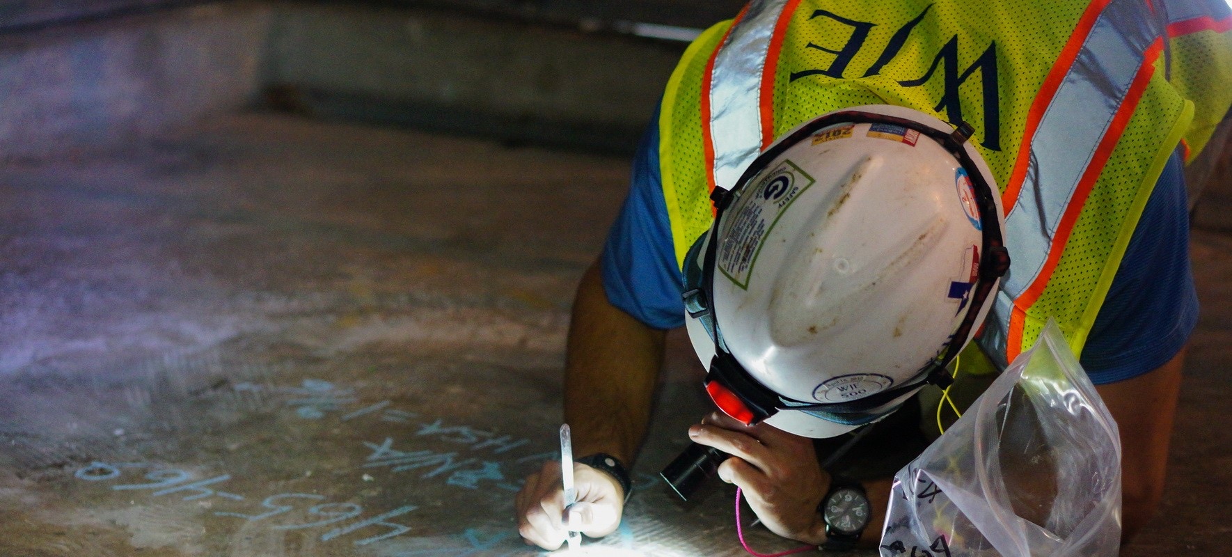 A WJE engineer marks findings on a concrete surface during a field investigation. Photo courtesy of WJE.